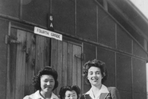 Three women standing outside Poston Camp school building (ddr-ajah-6-174)