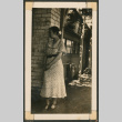 Woman leaning against a building (ddr-densho-433-820)