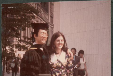 Man in graduation robe with woman (ddr-densho-523-521)