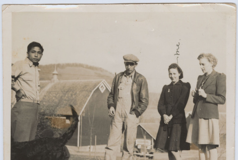 Four people in front of barn (ddr-janm-17-23)