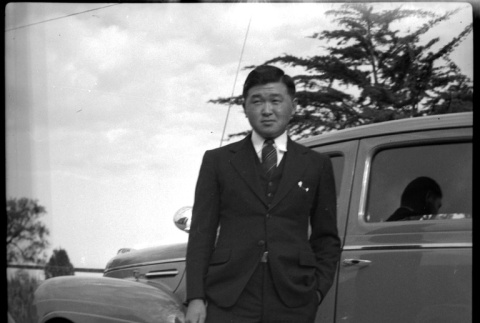 Man in a suit in front of car (ddr-densho-475-80)