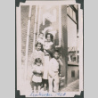 Woman with four children standing by brick building (ddr-densho-483-649)