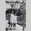 Two girls standing on dock by masted ship (ddr-densho-522-28)
