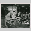 Mary Mon Toy sitting at a bar with two men (ddr-densho-367-112)