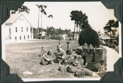 Group of men sitting with pile of gear (ddr-ajah-2-116)