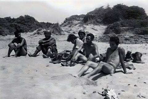 Six men relaxing on the beach, two in uniform (ddr-densho-474-244)