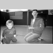 Man with child on gym floor (ddr-densho-1007-1259)
