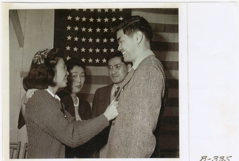 Yoriko (Shimasaki) Kitagawa, Katherine (Kageyama) Matsuki, Paul Matsuki, and Saburo Arthur Kitagawa standing in front of U.S. flag (ddr-densho-539-10)