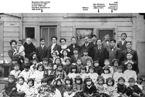 Group of adults and children posing for photo outside building (ddr-ajah-4-37)