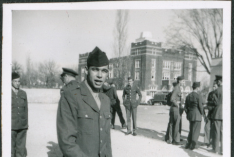 Man standing outside, group of men in background (ddr-densho-434-490)