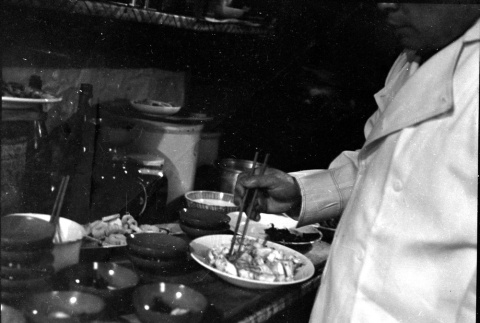 Man serving food into small bowls (ddr-densho-426-2151)