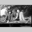Martha (Nozawa) Tsuchida Suzuki and Tomoye (Nozawa) Takahashi seated on a blanket outside (ddr-densho-426-1737)