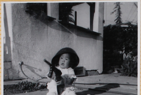 Susan Shiomi playing with toy gun (ddr-densho-522-269)