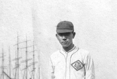 Man in baseball uniform with ships in background (ddr-ajah-5-57)