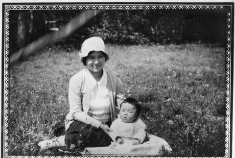Woman sitting in field with baby (ddr-ajah-6-671)