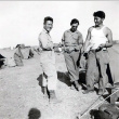 Three men in fatigues standing by tents (ddr-densho-474-239)