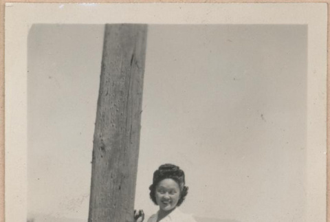 Woman standing next to a telephone pole (ddr-manz-10-68)