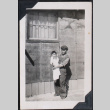 Man holding baby outside barracks (ddr-densho-467-15)