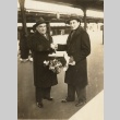 Two men shaking hands in a train station (ddr-njpa-1-2028)