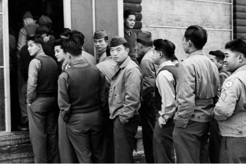 Men standing in line outside building (ddr-ajah-2-787)
