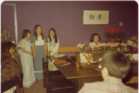 Three girls standing by piano (ddr-densho-426-134)