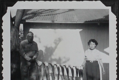 A man and woman holding stripped bass (ddr-densho-300-426)