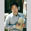 Ron Koshiyama holding notebooks (ddr-densho-336-1233)