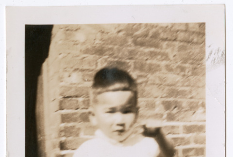 Photo of a toddler sitting and holding a lunch pail (ddr-densho-483-746)