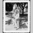 Man with stack of books standing by water fountain (ddr-densho-434-453)