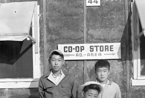 Three boys in front of the Minidoka Co-Op Store (ddr-fom-1-596)