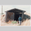 Photo of Kenji Ima entering a barn (ddr-densho-483-12)