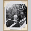 Man rests in front of waterfall (ddr-densho-404-390)