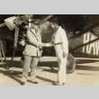 Two men shaking hands in front of an airplane (ddr-njpa-1-2338)
