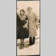 Couple standing on sidewalk in snow (ddr-densho-523-32)