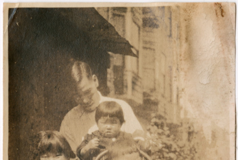 Man with children outside building (ddr-densho-426-1439)