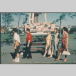 Five people walking past Mural stage at Seattle Center (ddr-densho-523-436)