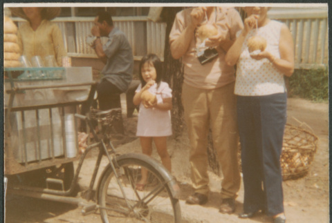 Two people and girl at sidewalk bicycle vendor (ddr-densho-523-508)