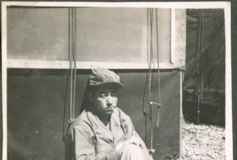 Soldier seated next to a tent (ddr-densho-201-499)