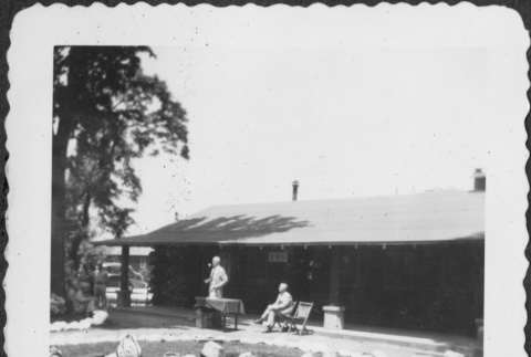 Group of men sitting on ground listening to man giving speech (ddr-densho-434-403)
