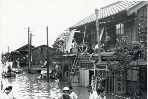 Japanese villagers walk through the flooded streets of their hometown (ddr-densho-299-115)