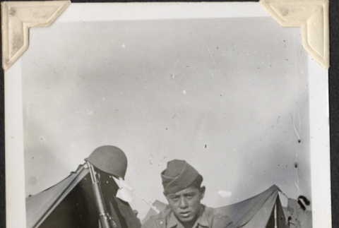 Man sitting outside tent, second man inside tent (ddr-densho-466-754)