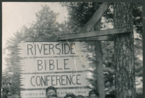 Group standing in front of a Riverside Bible Conference sign (ddr-densho-523-214)