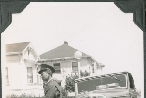 Man in uniform sitting on fender of car (ddr-ajah-2-151)