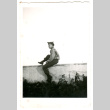 Soldier sitting on ledge (ddr-densho-368-210)