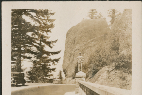 Man standing on railing alongside road (ddr-densho-316-255)