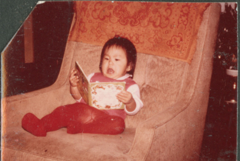 Girl with book in chair (ddr-densho-523-506)