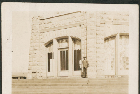 Man on steps outside stone building (ddr-densho-316-224)