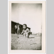 Toddler with couple in background outside barracks (ddr-densho-329-1336)