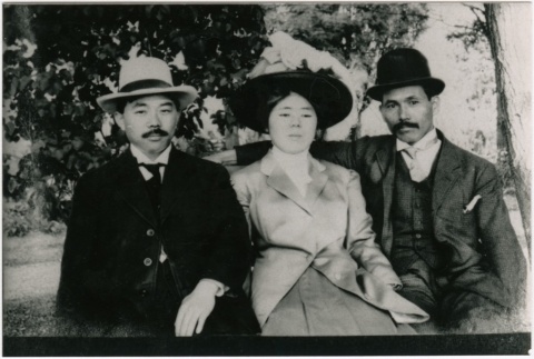 A woman and two men sitting together outside (ddr-densho-353-219)