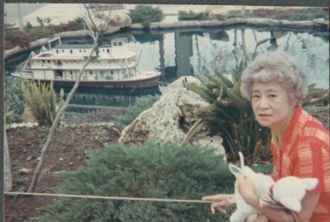 Agnes Sakura by pond with model boat (ddr-densho-523-656)